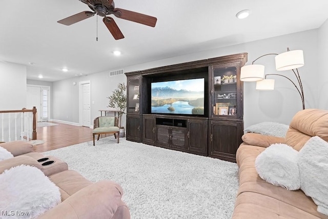 living room with baseboards, visible vents, wood finished floors, and recessed lighting