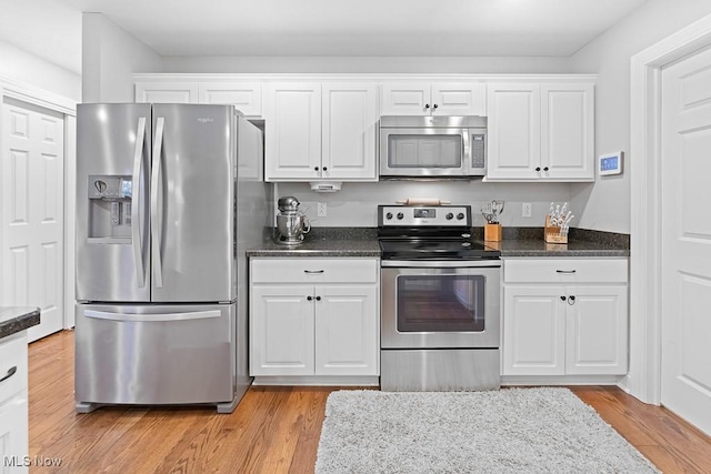 kitchen featuring appliances with stainless steel finishes, light wood-type flooring, and white cabinetry