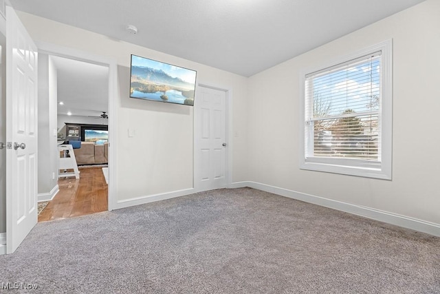 unfurnished room featuring carpet floors and baseboards