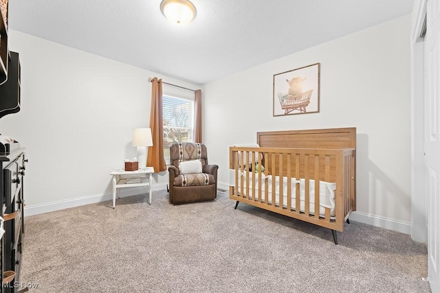 bedroom with a nursery area, baseboards, and carpet flooring