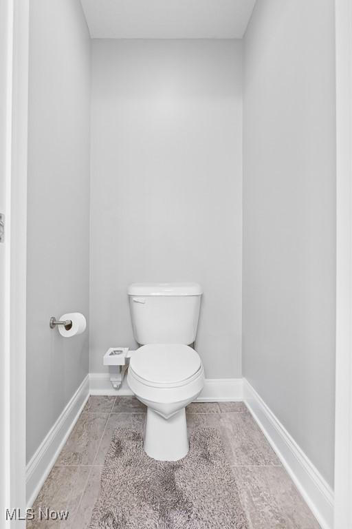 bathroom with baseboards and toilet