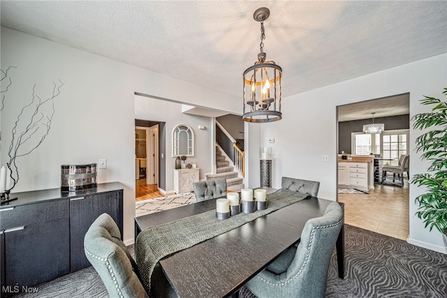 dining room with an inviting chandelier, stairs, baseboards, and a textured ceiling