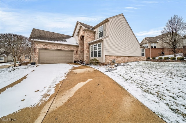 view of front facade featuring brick siding, driveway, and an attached garage