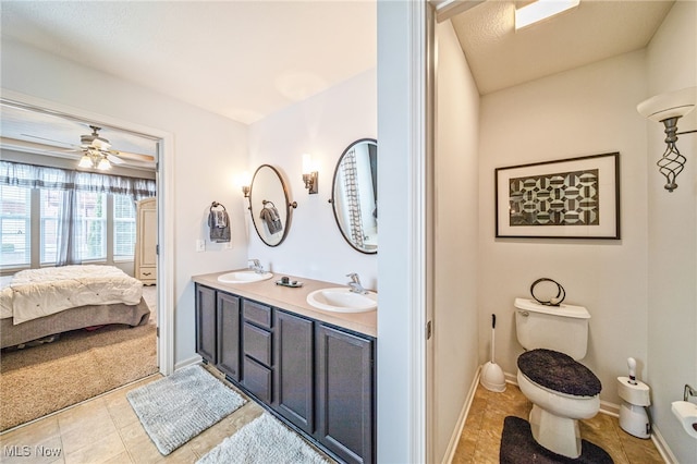 full bath featuring double vanity, a sink, toilet, and connected bathroom