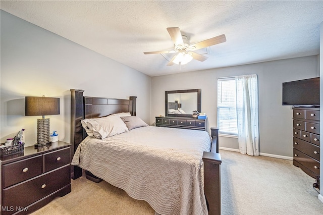 bedroom featuring a ceiling fan, carpet, a textured ceiling, and baseboards