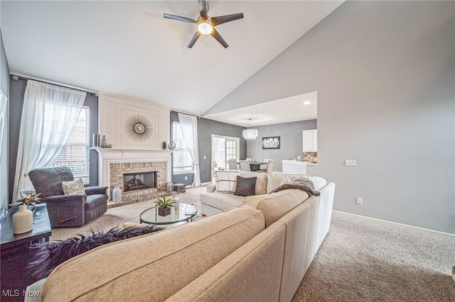 carpeted living room featuring a brick fireplace, ceiling fan, baseboards, and high vaulted ceiling