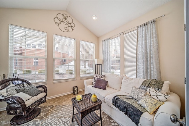 living room featuring lofted ceiling and baseboards