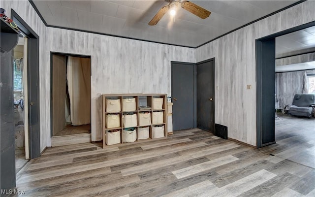 spare room featuring wood finished floors, a ceiling fan, and crown molding