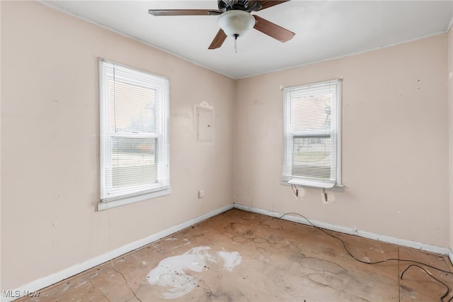 spare room featuring a ceiling fan and baseboards