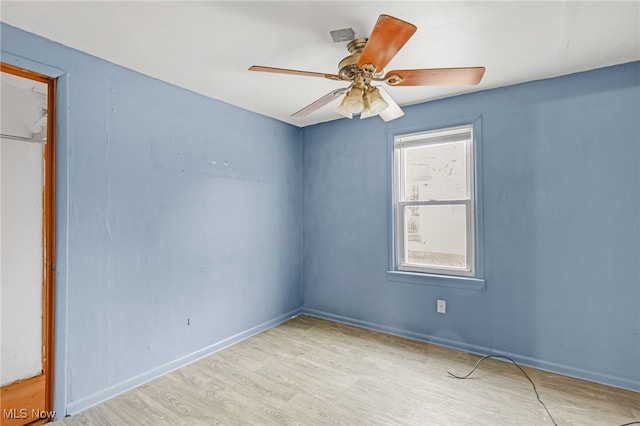 unfurnished room featuring a ceiling fan, baseboards, and wood finished floors