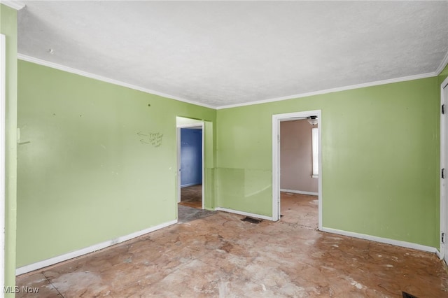 spare room featuring baseboards and crown molding