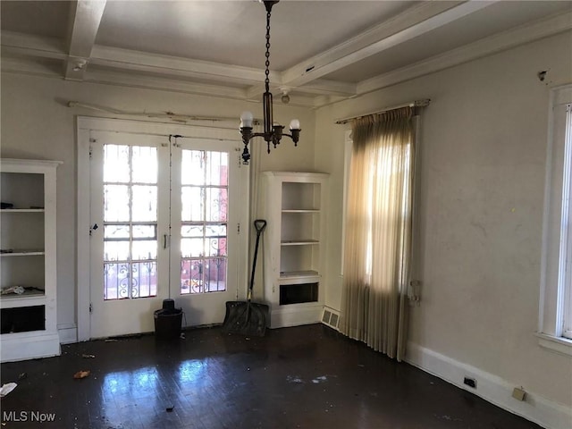 unfurnished dining area with a chandelier, beamed ceiling, coffered ceiling, and wood finished floors