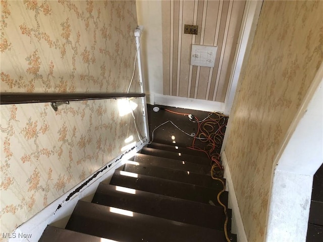 staircase featuring baseboards and wallpapered walls