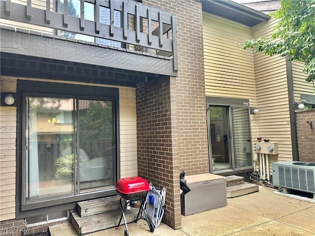 exterior space with central AC and brick siding