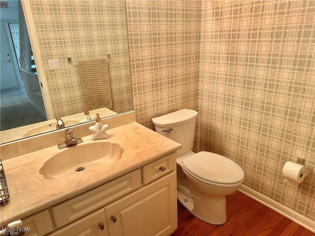 bathroom featuring toilet, wood finished floors, and vanity