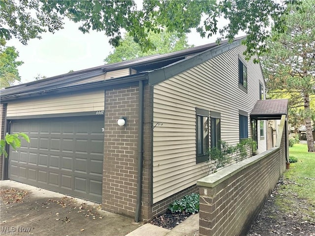 view of property exterior with a garage and brick siding