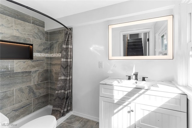 full bath featuring toilet, a shower stall, vanity, and baseboards