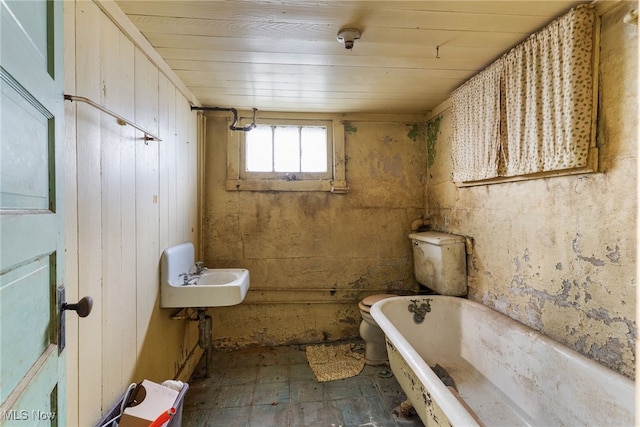 bathroom featuring wooden walls, a bath, wood ceiling, tile patterned floors, and a sink