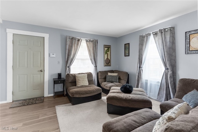 living room with light wood-style floors, plenty of natural light, and baseboards