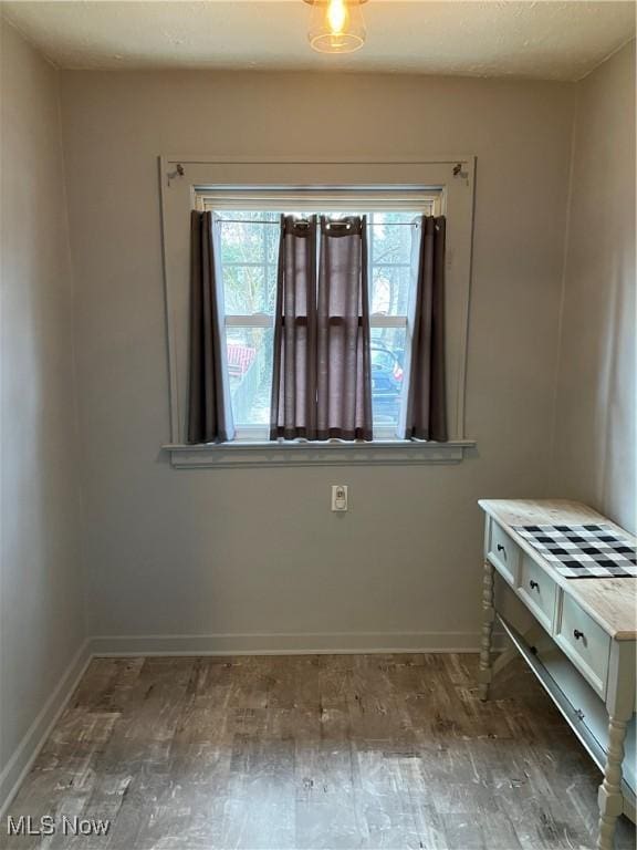 unfurnished bedroom featuring wood finished floors and baseboards