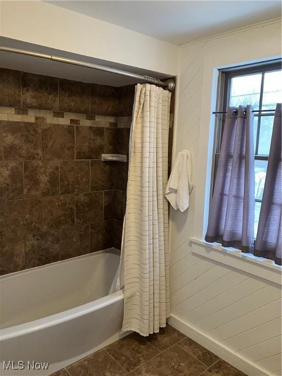 full bathroom with shower / tub combo, baseboards, and tile patterned floors