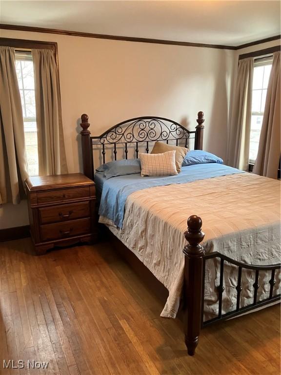 bedroom with ornamental molding and wood-type flooring