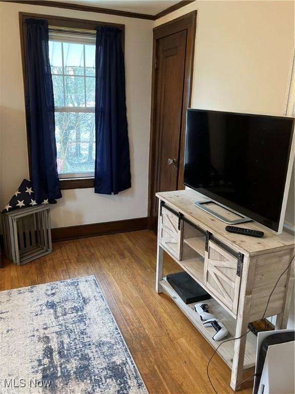 bedroom featuring crown molding, wood finished floors, and baseboards