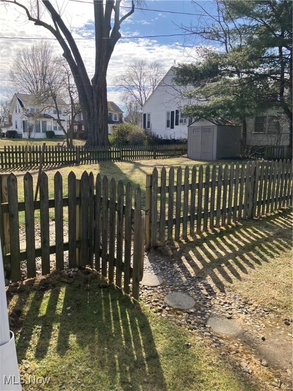 view of yard with an outbuilding, a shed, fence private yard, and a residential view