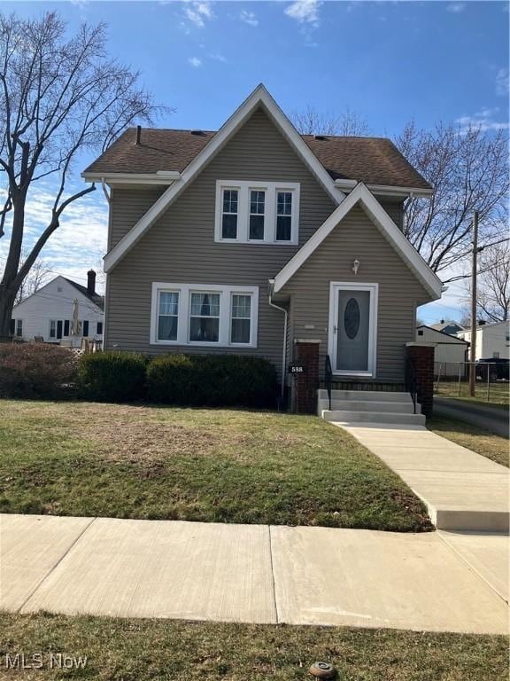 traditional-style house featuring entry steps and a front yard