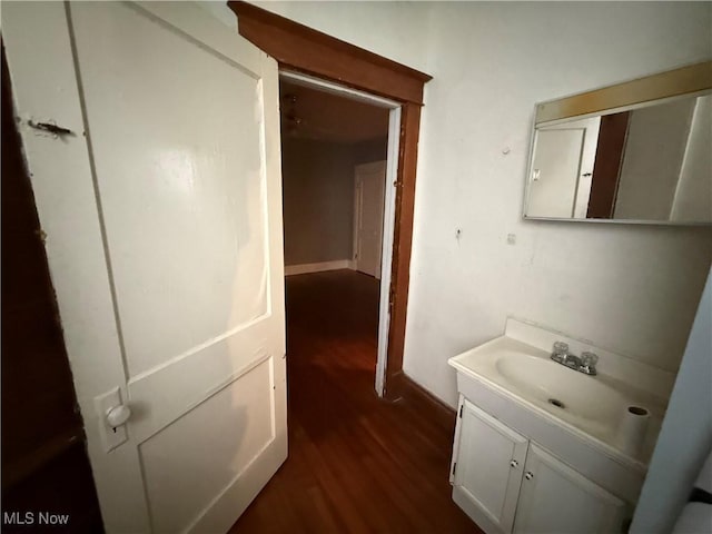 bathroom with baseboards, wood finished floors, and vanity