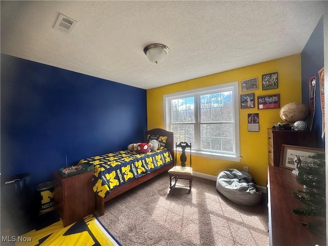 carpeted bedroom with a textured ceiling, visible vents, and baseboards