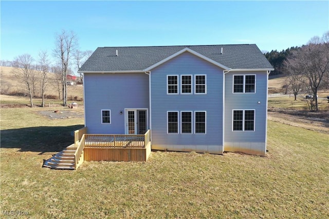 rear view of house with a shingled roof, a lawn, and a wooden deck