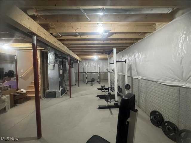 exercise area featuring heating unit and gas water heater