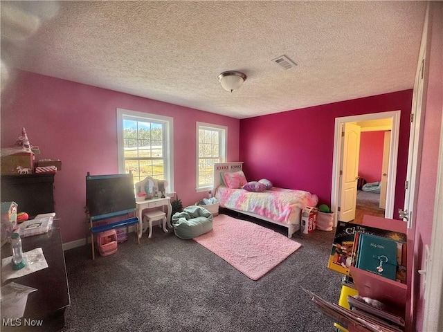 bedroom with a textured ceiling, carpet floors, and visible vents