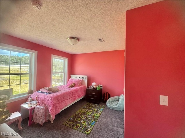 carpeted bedroom with visible vents and a textured ceiling