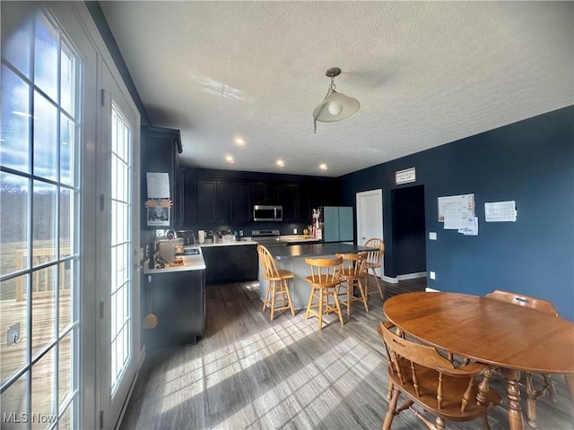 dining area with a textured ceiling and wood finished floors