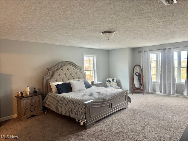 bedroom with carpet floors, multiple windows, baseboards, and a textured ceiling