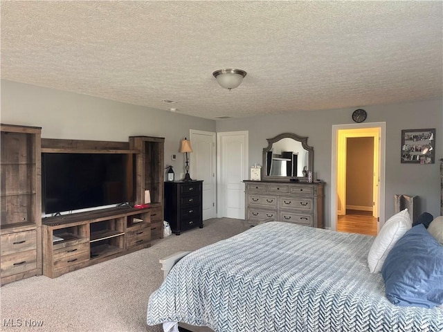 carpeted bedroom featuring a closet and a textured ceiling