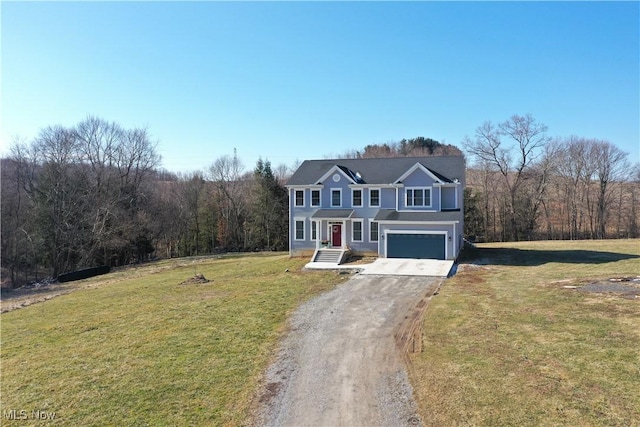 traditional home with a wooded view, an attached garage, driveway, and a front lawn