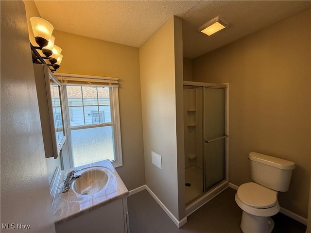 bathroom with baseboards, toilet, a textured ceiling, vanity, and a shower stall