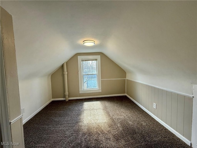 additional living space featuring carpet flooring, vaulted ceiling, and baseboards