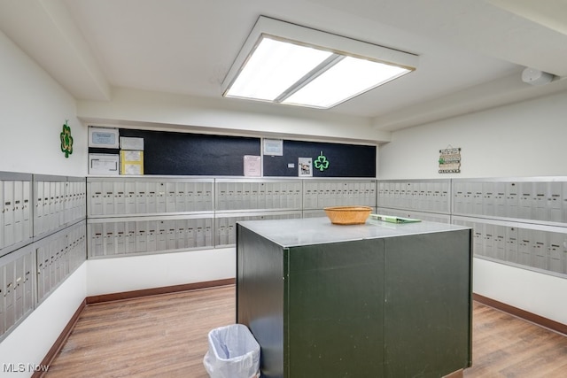 kitchen featuring baseboards, light wood-style flooring, and a center island