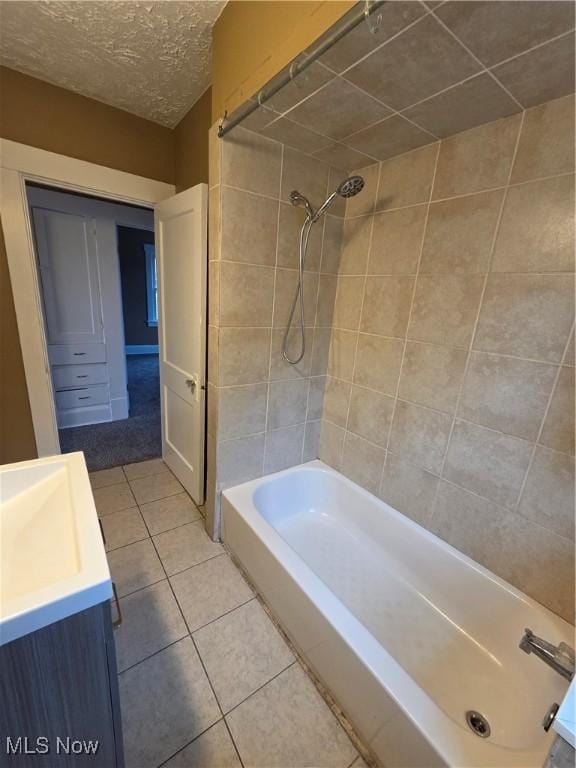 bathroom with a textured ceiling, shower / bathtub combination, vanity, and tile patterned floors