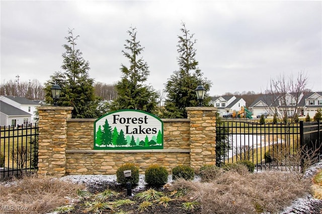 community / neighborhood sign with fence and a residential view