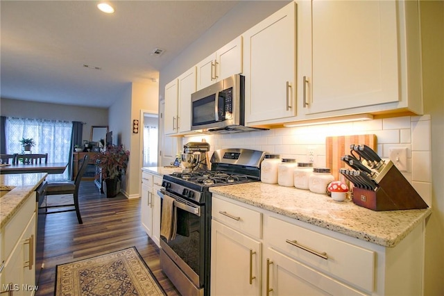 kitchen featuring visible vents, white cabinets, appliances with stainless steel finishes, backsplash, and light stone countertops