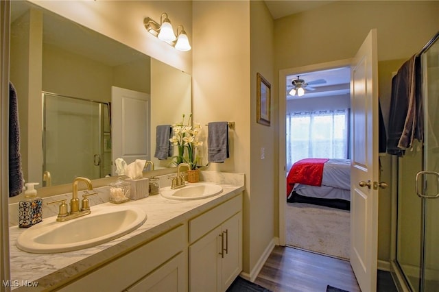 ensuite bathroom with connected bathroom, a stall shower, a sink, and double vanity