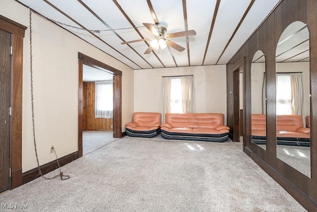 living area with carpet and ceiling fan