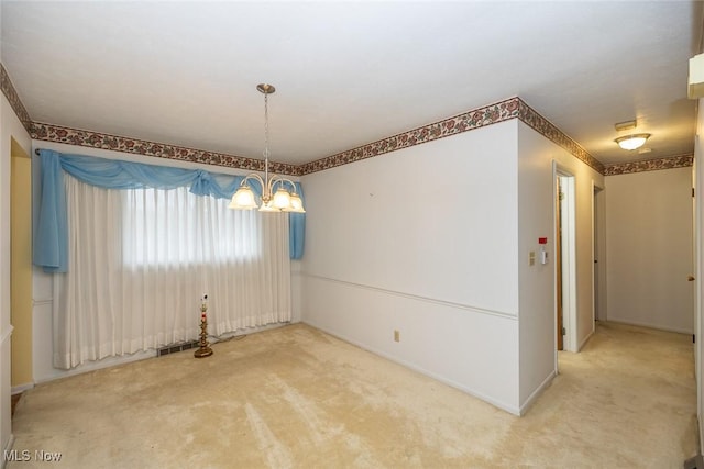 carpeted spare room with visible vents and a chandelier