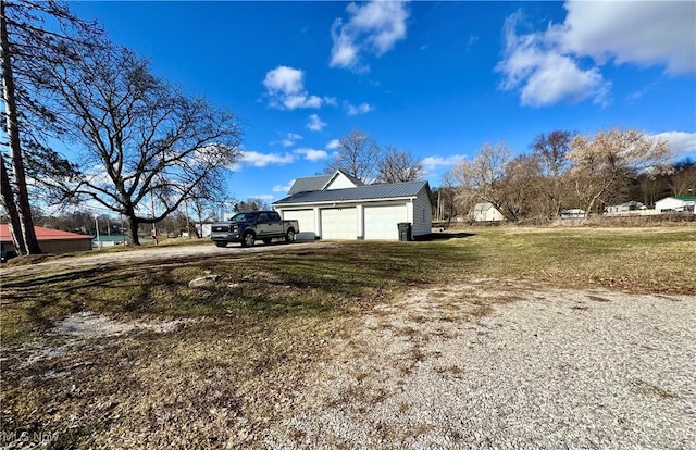 view of side of home featuring driveway, an outdoor structure, and a yard