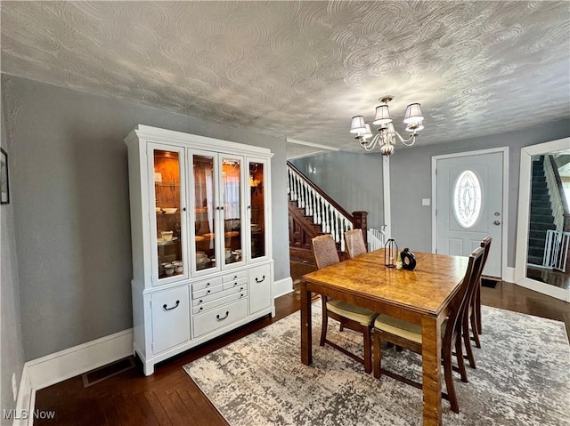 dining room with dark wood-style floors, baseboards, stairs, and visible vents